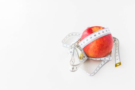 A Red apple bind with tape measure for concept loss weight and diet healthyの写真素材
