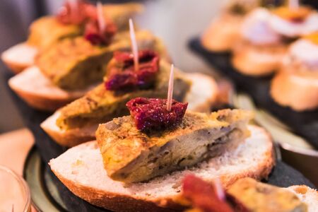 A closeup of a typical spanish pincho de tortilla, spanish omelete served on bread. Spanish tapas called pintxos of the Basque countryの写真素材
