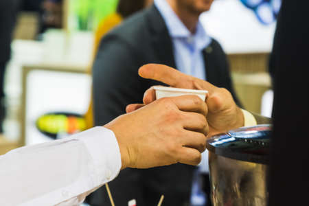 A hand serving a cup of coffeeの写真素材