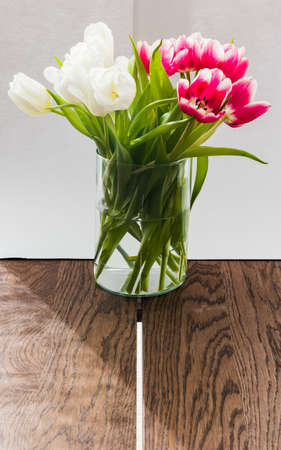 A vase with tulips on wooden tableの写真素材