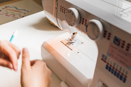 A woman hands using sewing machineの写真素材