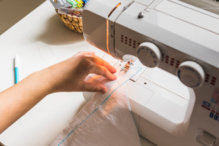 A woman hands using sewing machineの写真素材