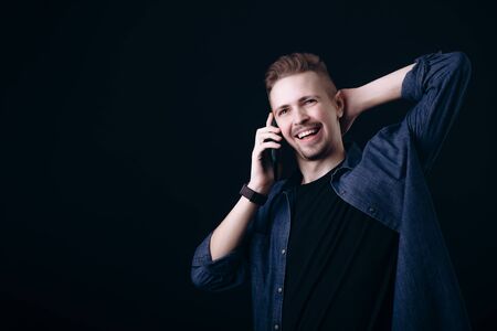 Smiling Youngster Talking on Smartphone and Stretching Himself