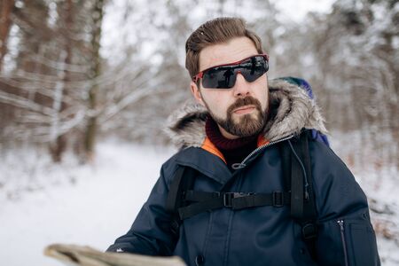 Virile Bearded Tourist in Mirrored Sunglasses in Winter Forest