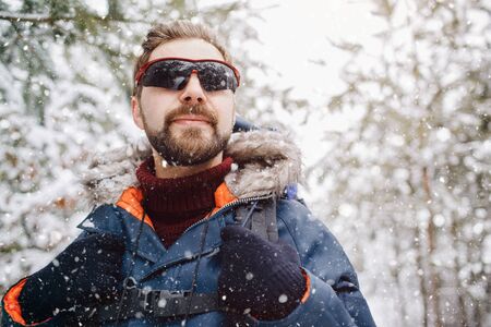 A Man Enjoying Snowfall in Winter Forest