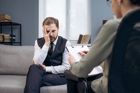 Mature man sitting on couch at psychologist office