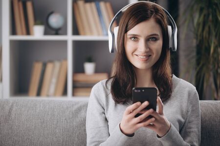 Portrait of girl in wireless headphones relaxing on couch