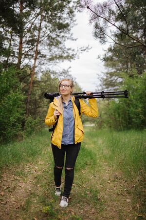 Photographer walking with professional equipment at forestの写真素材