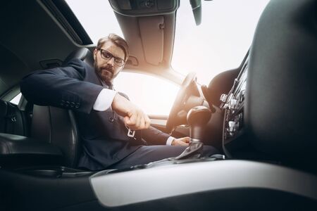 Responsible man fastening seat belt before driving car