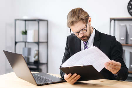 Focused man working with documents at office