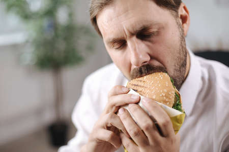 Businessman eating burger at office