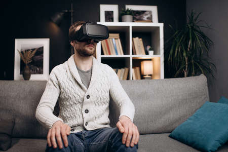 Young guy using VR headset during leisure timeの写真素材