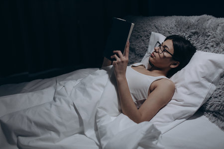 Woman reading in bedの写真素材