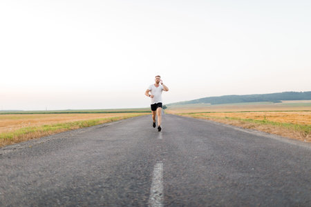 Man in earphones running outdoorsの写真素材