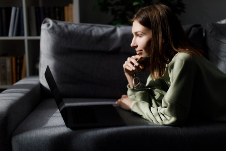 Woman with laptop on couch
