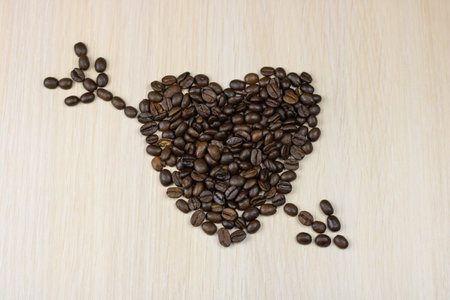 The coffee beans are laid out in the shape of a heart with an arrow.の写真素材