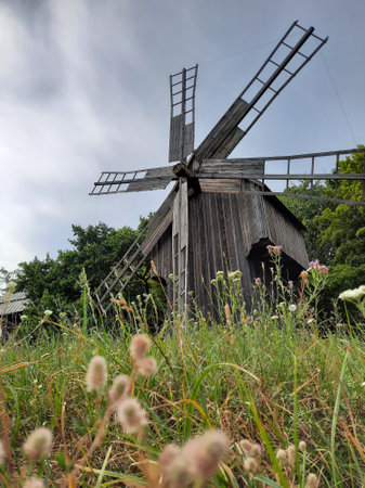 Old wooden windmill on a background of forest and sky.の写真素材
