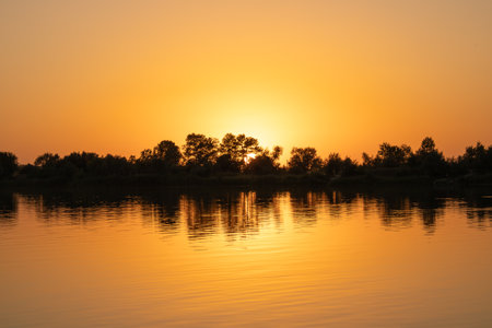 Sunset postcard nature. Calm water and sky. Orange background.の写真素材