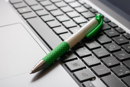 Laptop keyboard black on gray background with a pen on it. Close-up of laptop keyboard.の写真素材