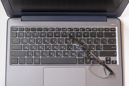 Laptop keyboard black on gray background with a glasses on it. Close-up of laptop keyboard.の写真素材