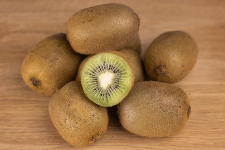 A bunch of kiwi fruit on a wooden table.の写真素材