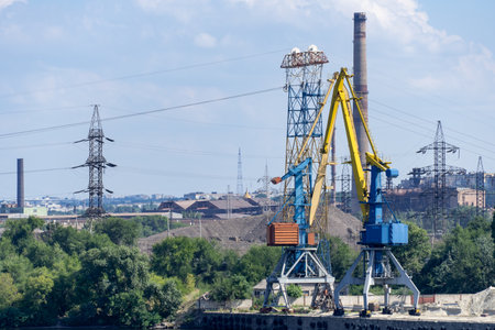 Big port cranes on river. Extraction and transportation sand. Harbor crane loads water resources...
