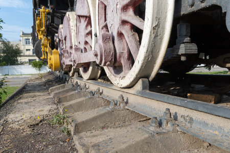 Close-up drive wheels and rods on steam engine locomotive. Vintage part of suspension of old train. Details rarity railway transport - lever and chassis, axle and connection.の写真素材