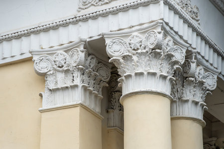 Architectural columns with figures and white stucco wealth. Solemn entrance to city park is made in...
