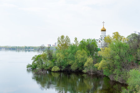 Church with golden houses and place religion of orthodox Christian. Beautiful landscape with green park in middle of river. View of monastyrsky island with church in Dnipro Ukraine.の写真素材