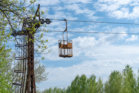 Abandoned cableway for transporting people in amusement park. Old obsolete suspension road across river. Vintage rusty cable car in the city Dnepr. Soviet union technology.の写真素材