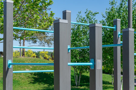 Outdoor sports ground in the city park. Street exercise equipment with horizontal bars, columns and...