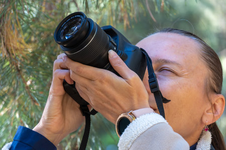 Woman photographer walking and taking picture photo of forest landscape on camera. Shooting nature.