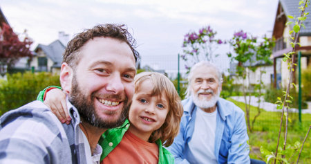 POV of happy man taking selfie video or videochatting and little cute son sending air kisses and...