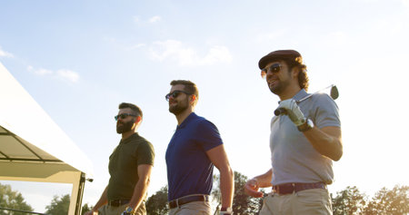 Three Caucasian attractive men with clubs going to start playing golf on the nice sunny day. Outdoorsの写真素材