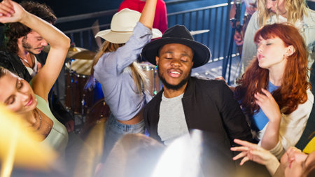 Young african american man dancing on a rooftop party enjoying time with friends. Fun time with...