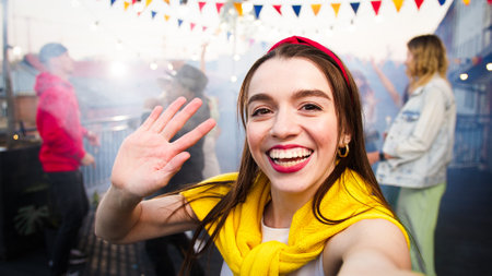 Young caucasian woman making video with her african american friend on a party, singing and smiling...