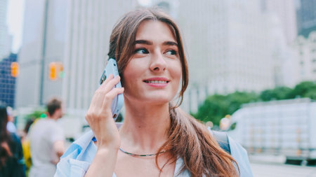 Close-up portrait of stylish young woman walking in big modern city, talking by mobile phone. Discussion, cellphone and urban city person, consultant or agent talking, speaking or in conversation.の写真素材