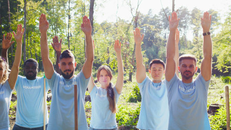 Enthusiastic multicultural volunteering organization concerned about natural environment pollution. Cheerful volunteer, friends putting their hands up to the sky. Wellness, nature protection conceptの写真素材