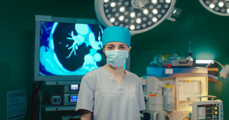 Portrait of woman in protective mask and hat in clinic. Nurse is standing and looking at camera in...
