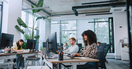 Group of busy managers working in spacious office. People entering text on keyboards and looking at...