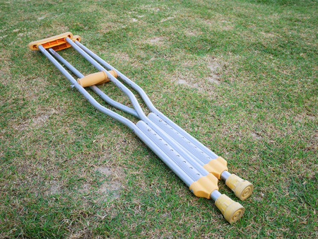 The aluminium of crutches for supporter the broken legs patient on the green grass fieldの写真素材