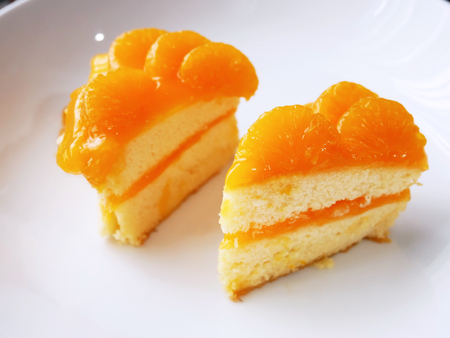 Fresh oragne cake on the white plate for coffee break time.の写真素材