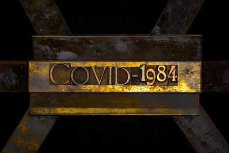 Photo of real authentic typeset letters forming Covid-1984 text on vintage textured grunge copper...