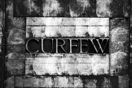 Photo of real authentic typeset letters forming Curfew text on vintage textured monochrome silver...