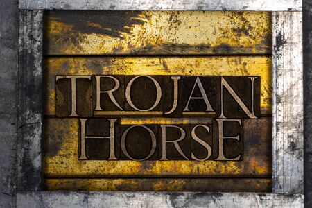 Photo of real authentic typeset letters forming Trojan Horse text on vintage textured silver grunge copper and gold backgroundの写真素材