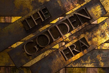 The Golden Era text formed with real authentic typeset letters on vintage textured silver grunge copper and gold backgroundの写真素材