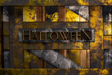 Halloween text formed with real authentic typeset letters on vintage textured silver grunge copper and gold backgroundの写真素材