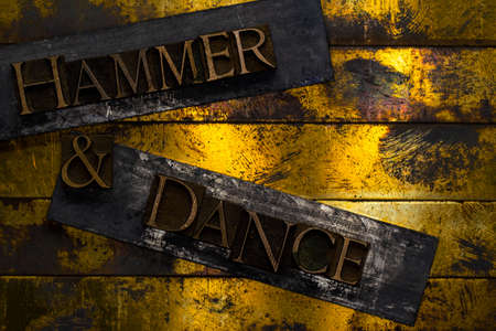 Hammer and Dance text formed with real authentic typeset letters on vintage textured silver grunge copper and gold backgroundの写真素材