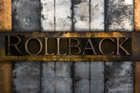 Rollback text formed with real authentic typeset letters on vintage textured silver grunge copper and gold backgroundの写真素材