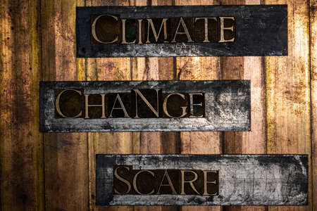 Climate Change Scare text formed with real authentic typeset letters on vintage textured silver grunge copper and gold backgroundの写真素材
